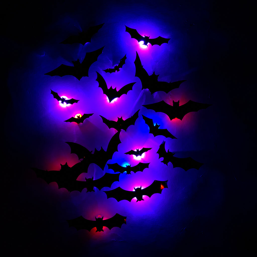 Real photo of the LED bat lights glowing purple and red in the dark